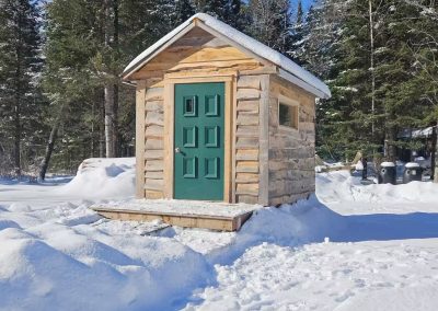 Extérieur de la cabane Le Poulailler avec porte verte en hiver, La Sôvageonne près du Mont-Tremblant