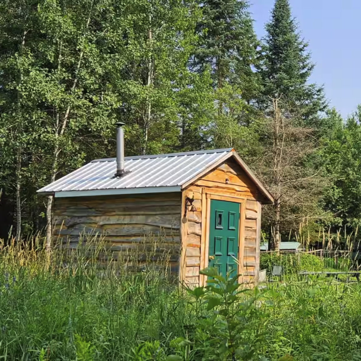 Cabane Le Poulailler entourée de verdure en été, hébergement prêt-à-camper près du Mont-Tremblant