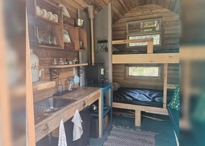 Vue d'ensemble de l'intérieur de la cabane Le Poulailler avec cuisinette et lits superposés