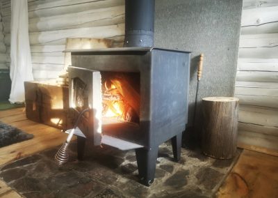 Poêle à bois allumé à l'intérieur de la cabane Jack's Camp